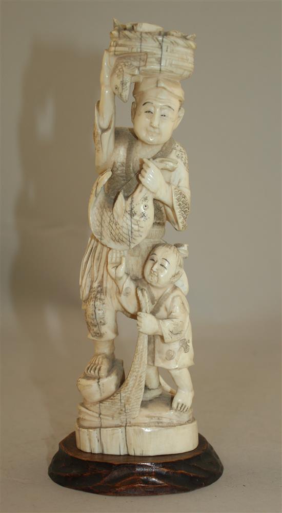 A Japanese walrus ivory group of a fisherman and a boy, early 20th century 21.5cm, wood stand